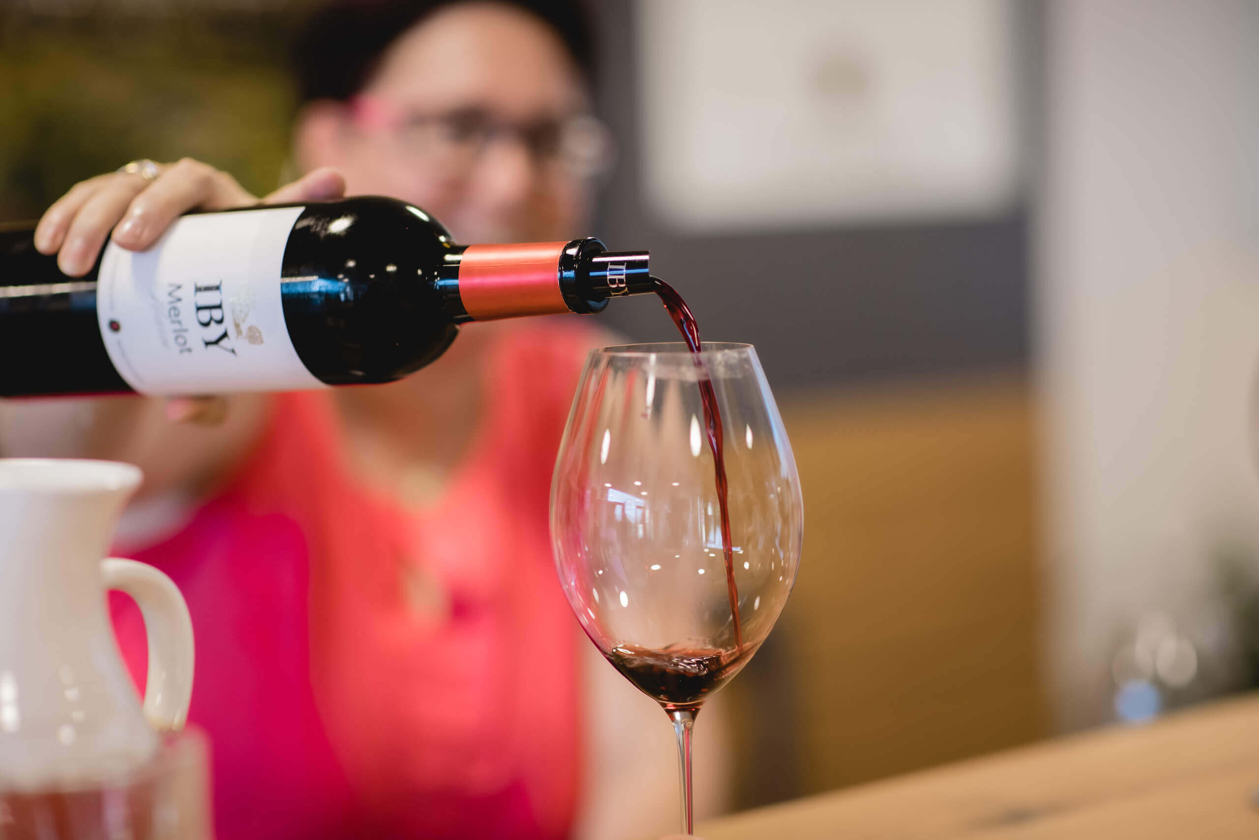 Eva Iby schenkt Rotwein in ein Glas